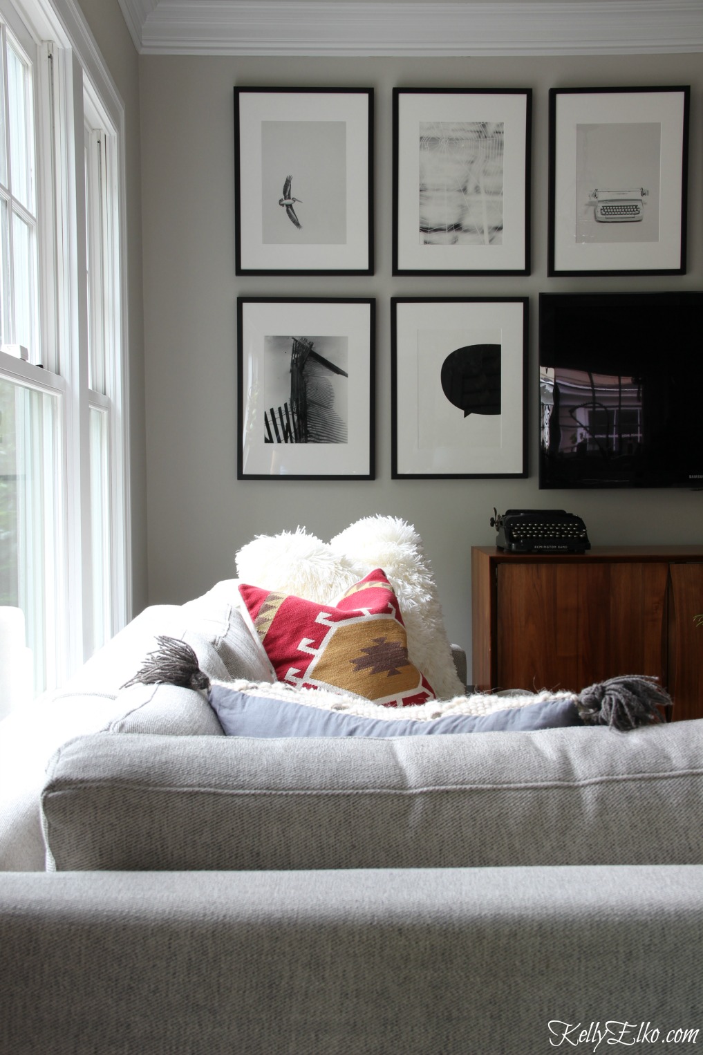 Cozy family room with dramatic black and white gallery wall around the TV kellyelko.com