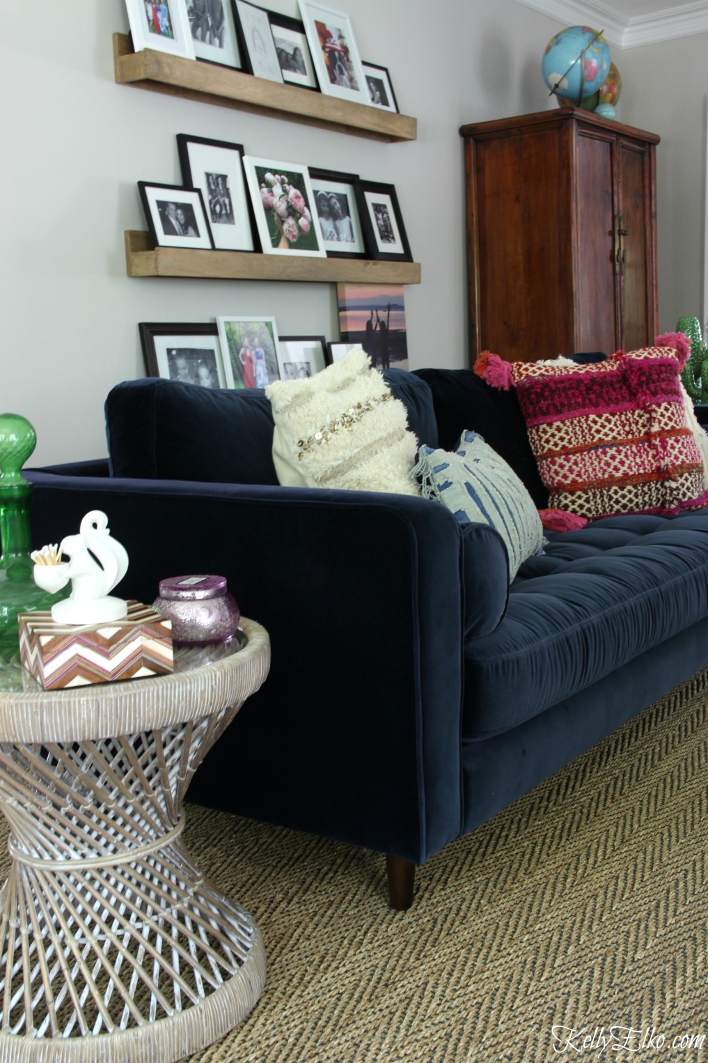 Colorful living room with blue velvet sofa and wood picture ledges for a family photo gallery wall kellyelko.com