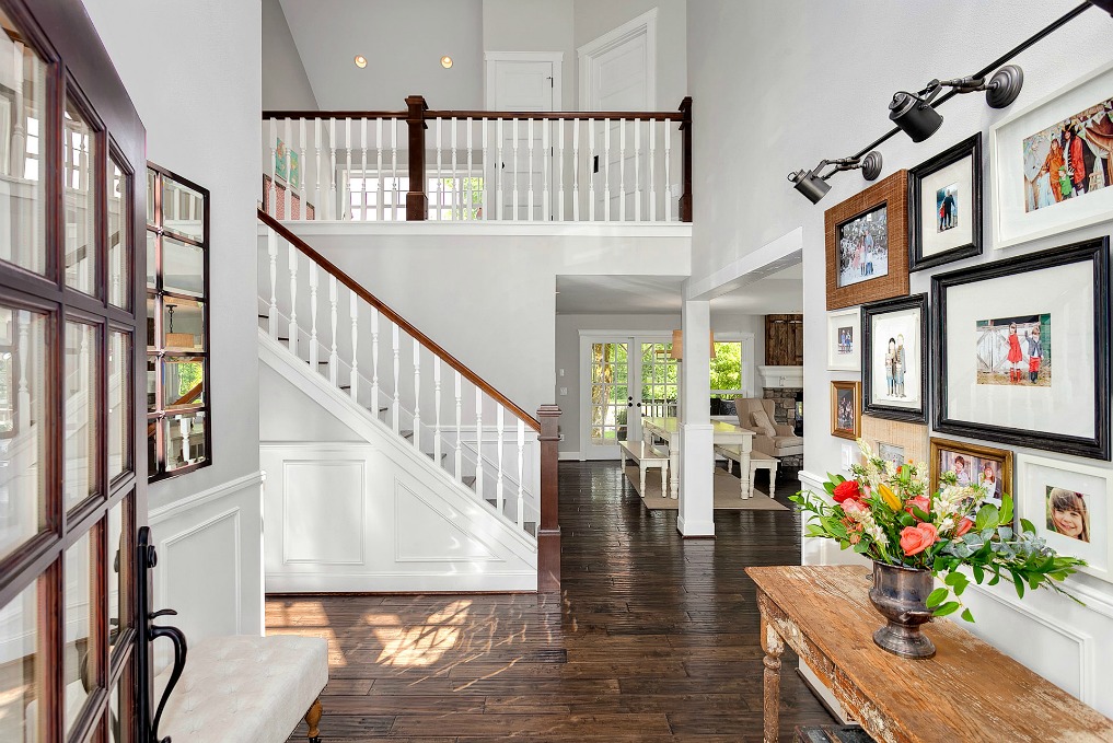 Love this foyer with dramatic staircase and family photo wall kellyelko.com