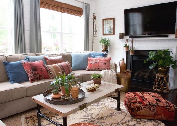 Colorful, boho family room with tribal rug and pouf kellyelko.com