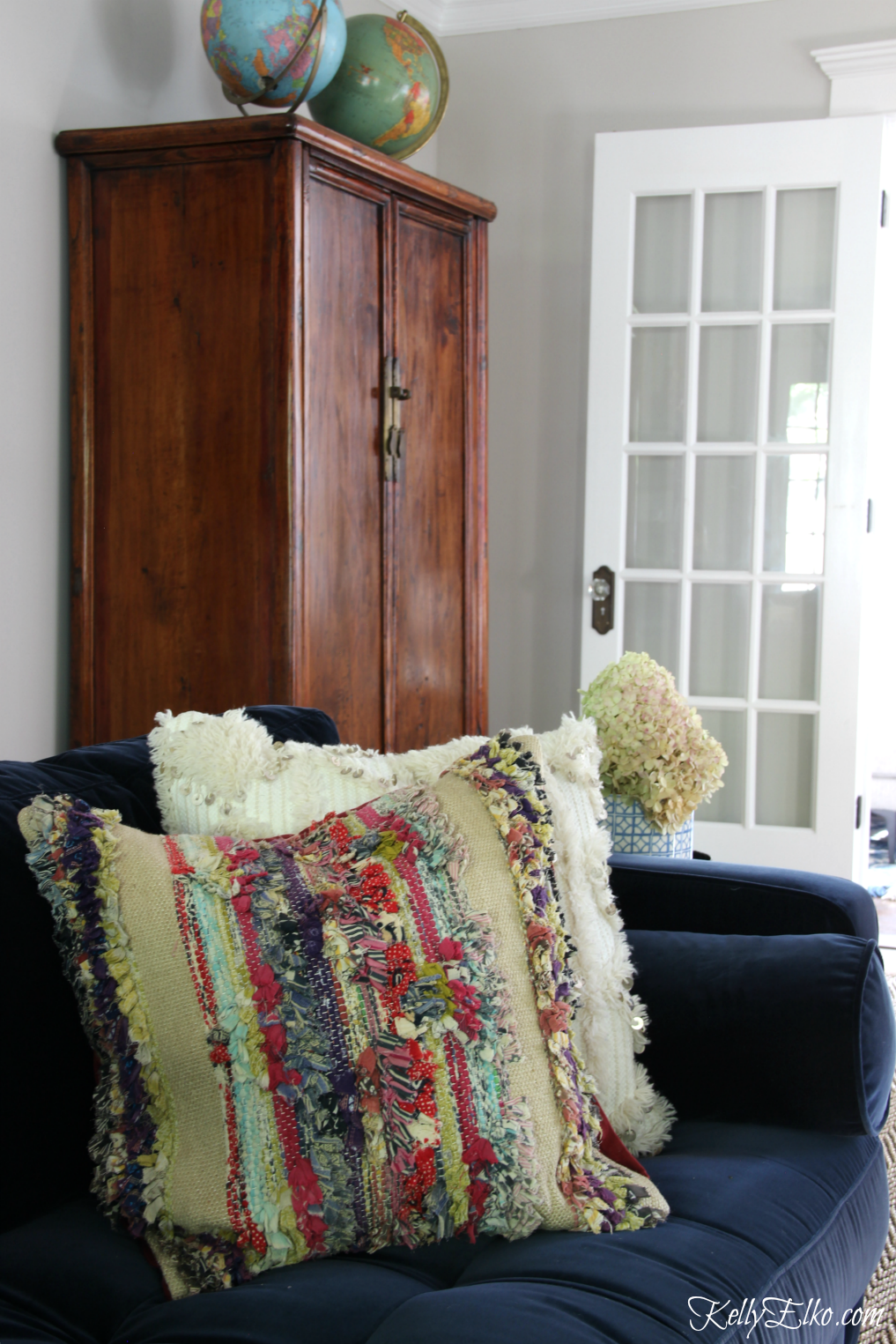 Colorful boho style pillows brighten up a navy blue sofa kellyelko.com