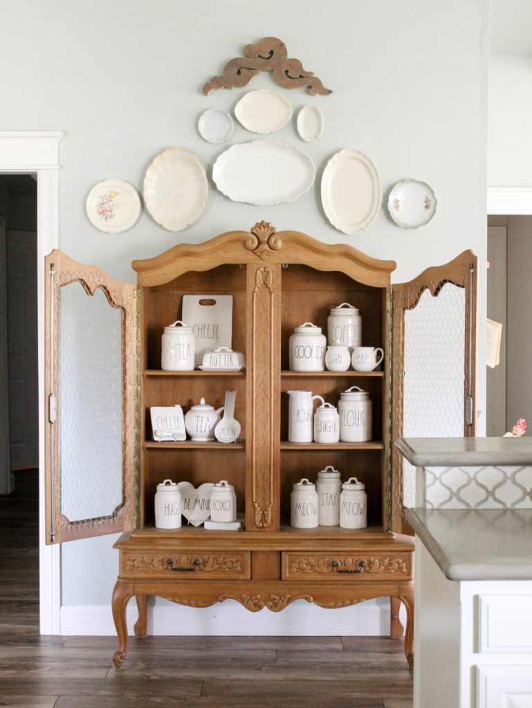 Farmhouse tour - love this antique cabinet displaying Rae Dunn collection