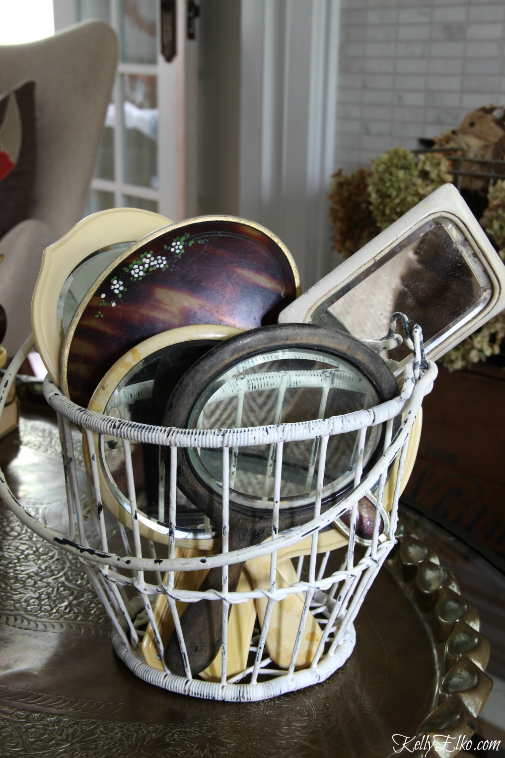 Collection of vintage hand mirrors displayed in a wire basket kellyelko.com