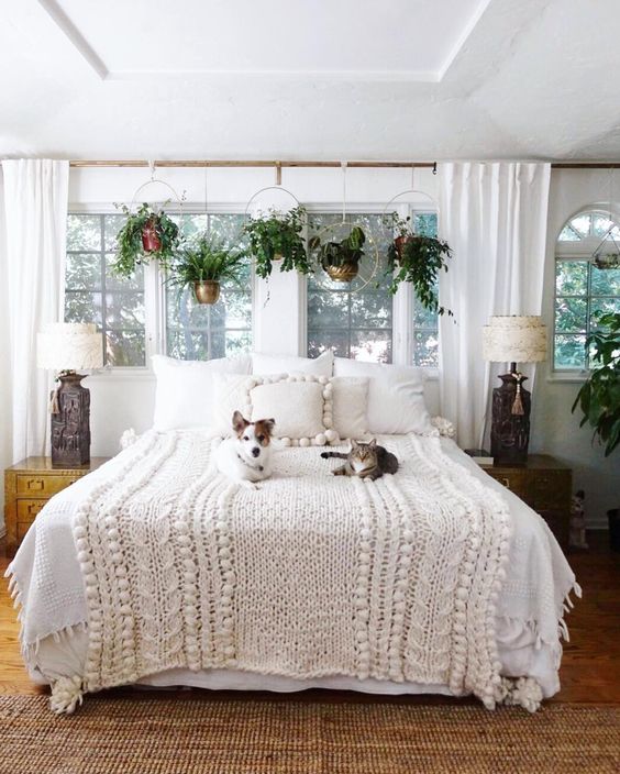 Boho bedroom with plant window treatment and chunky knit blanket