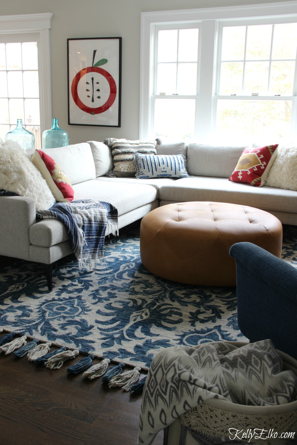 Cozy family room with sectional sofa, blue Loloi tassel rug and red pillows kellyelko.com #familyroom #sectional #homedecor #boho