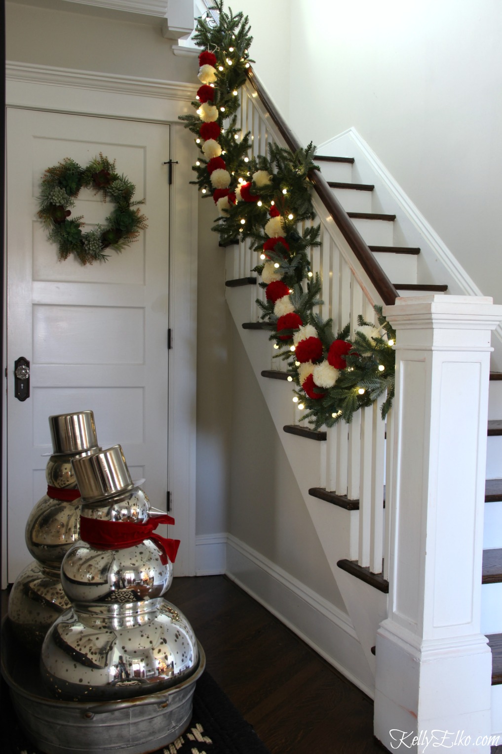 Christmas Home Tour - love this foyer with pom pom garland kellyelko.com