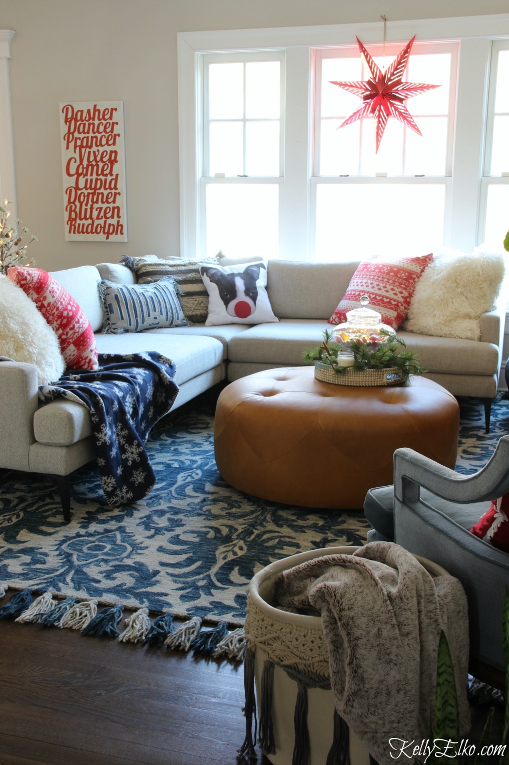 Christmas Home Tour - love this sectional sofa with fun pillows and the paper star in the window kellyelko.com