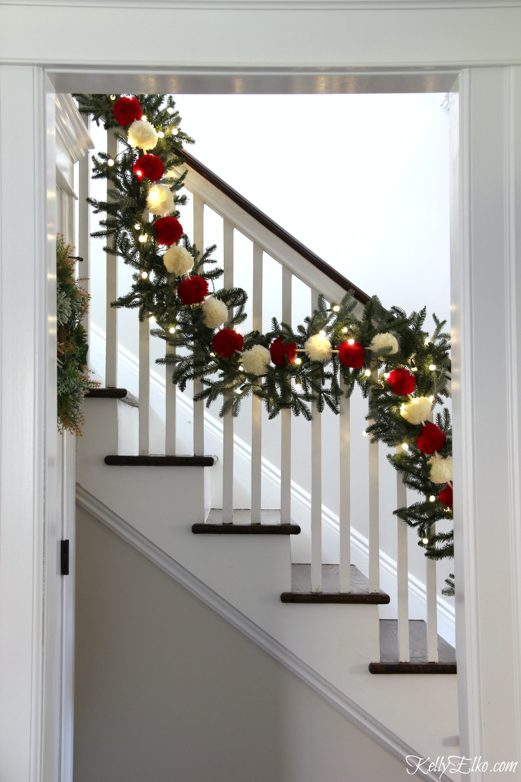 Christmas Home Tour - love this banister with pom pom garland kellyelko.com