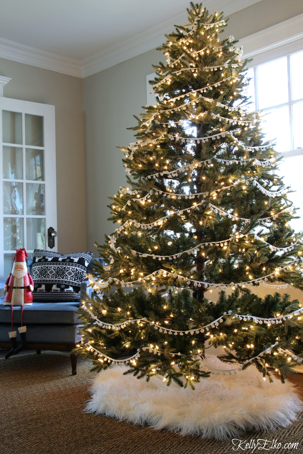 Christmas Home Tour - love this tree with pom pom garland and fur tree skirt kellyelko.com