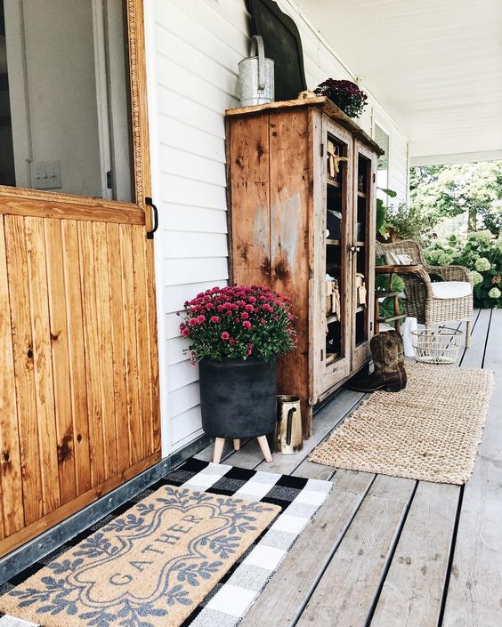 Farmhouse tour - love the porch with wood cabinet and wicker chair