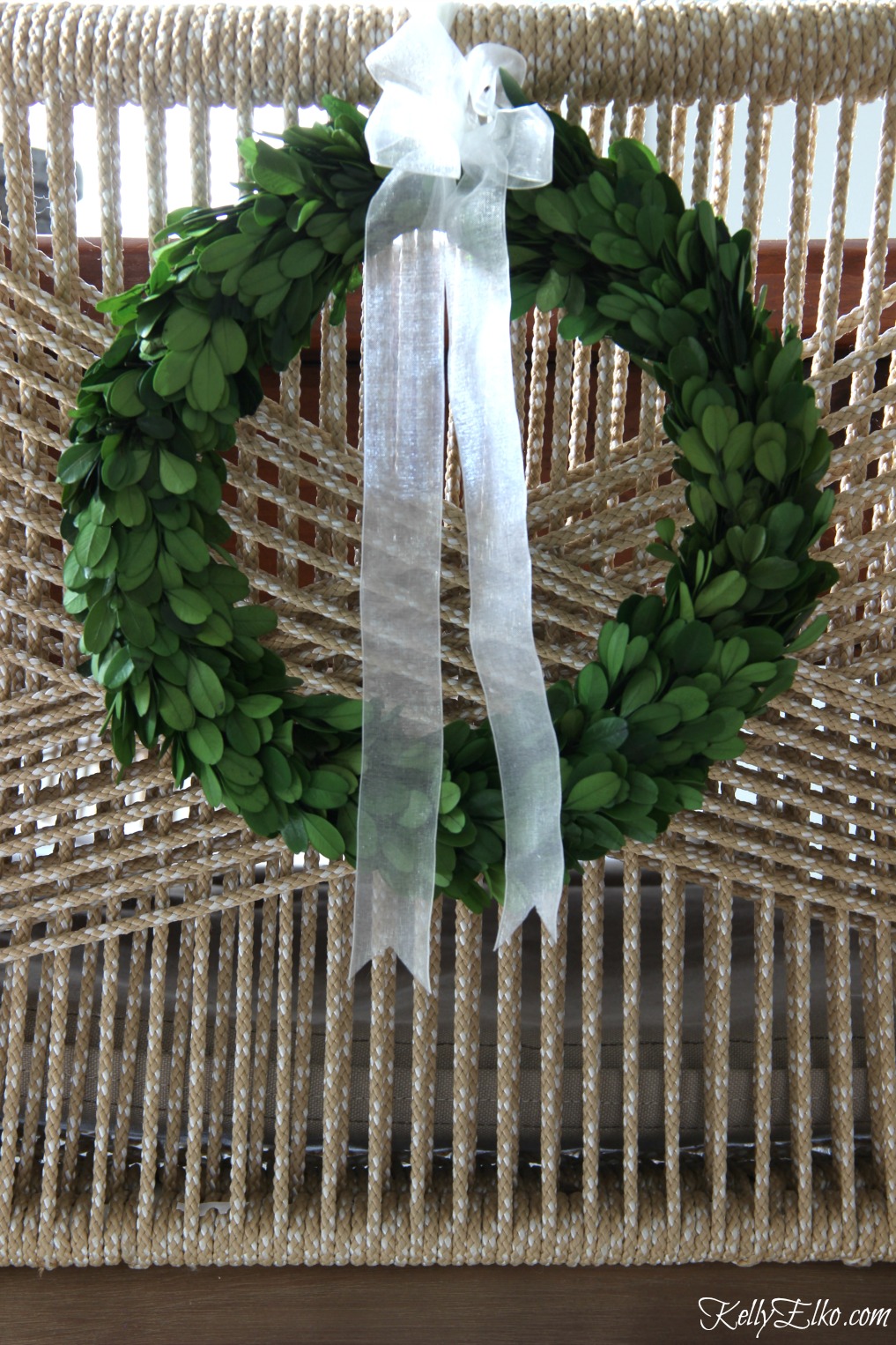 Tie preserved boxwood wreaths on back of chairs for the holidays kellyelko.com