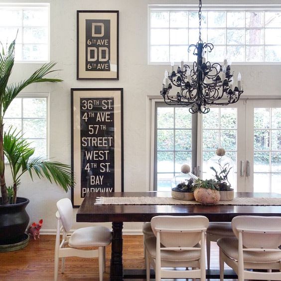 Beautiful dining room with mid century chairs, iron chandelier and NY subway art 