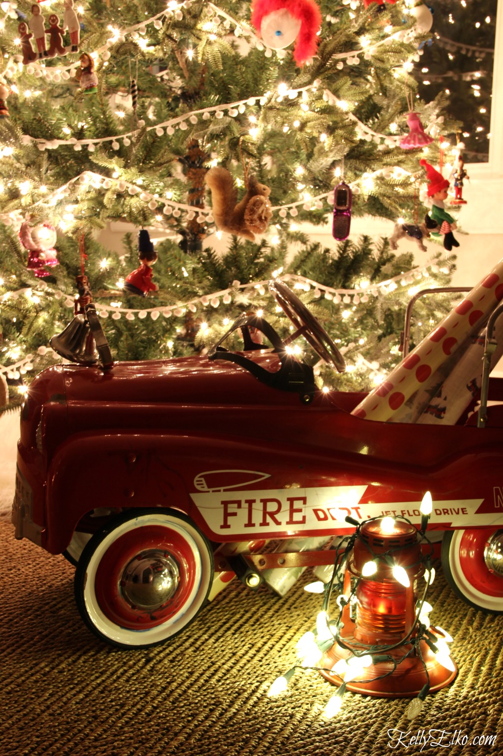 Christmas Nights Tour - see 25 of the best Christmas homes lit up at night! How fun is this cute little red fire truck filled with gift wrap kellyelko.com #christmas #christmasdecorating #christmasdecor #christmaslights