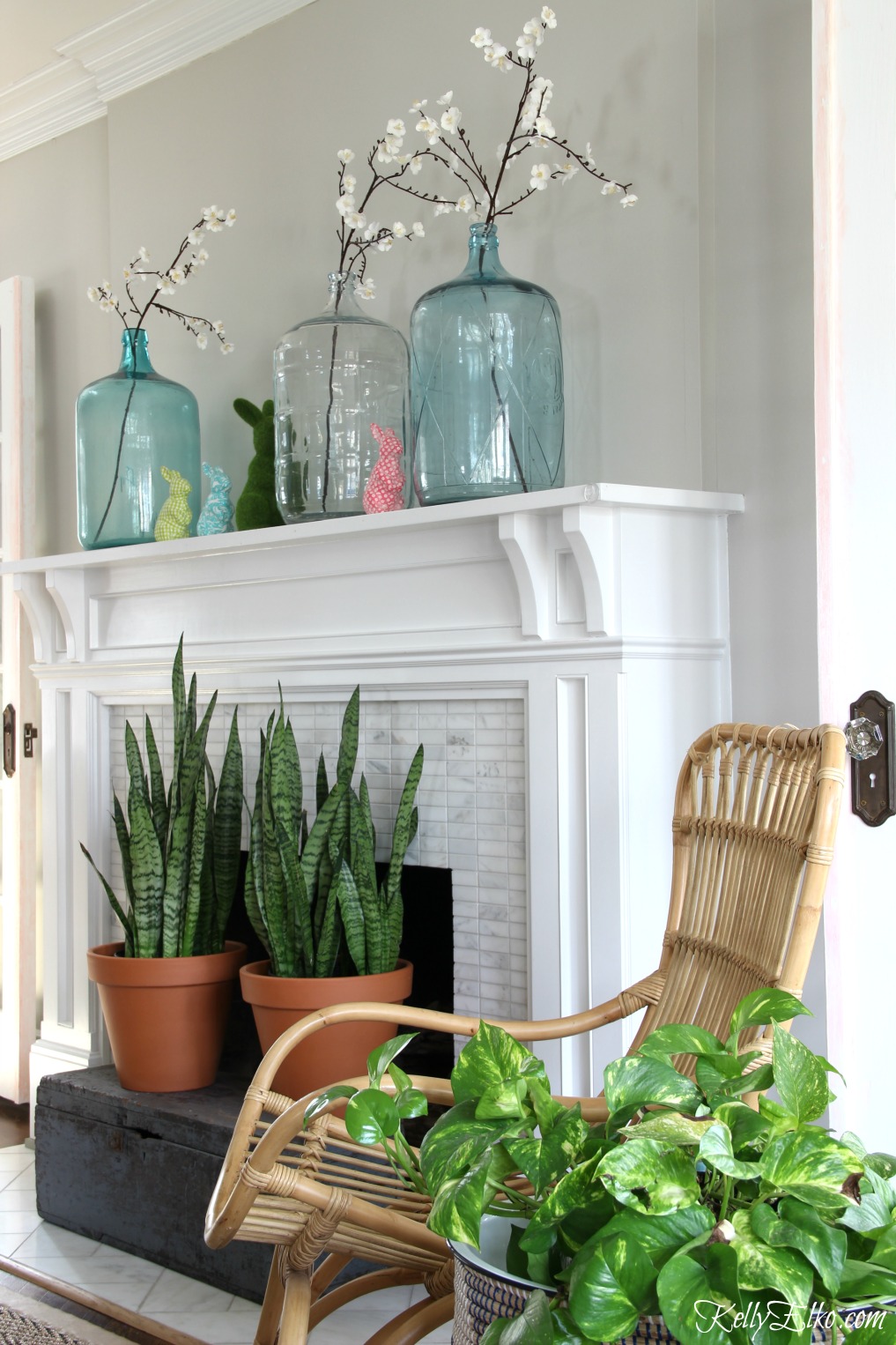 Spring Decorating Ideas - love this spring mantel with vintage demijohn jugs and colorful bunnies kellyelko.com #spring #springdecor #springmantel #vintagedecor #homedecor