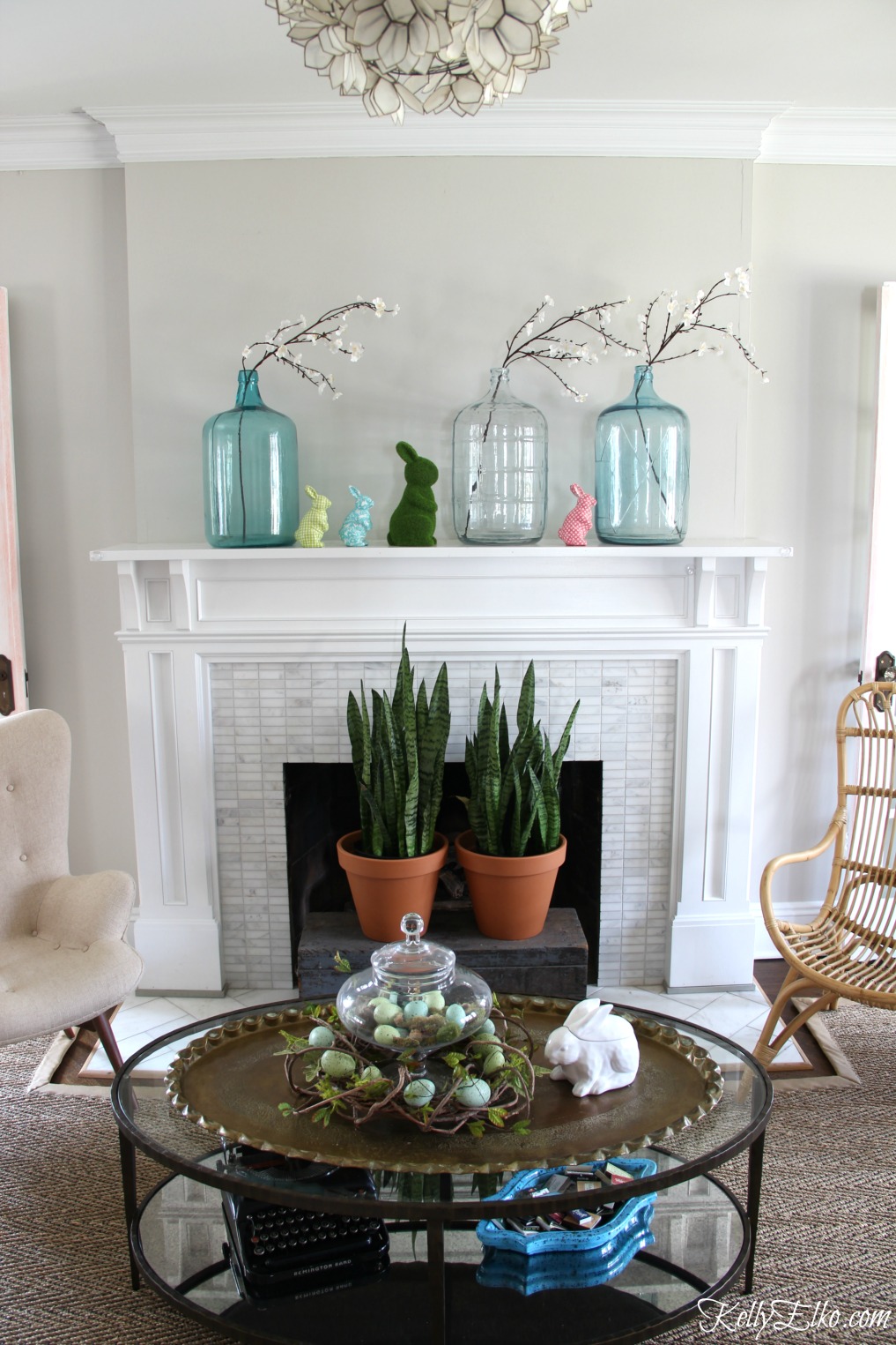 25 Spring Decorating Ideas - love this mantel with vintage glass demijohns, colorful bunnies and snake plants kellyelko.com #spring #springdecor #homedecor #mantel #springmantel #vintagedecor