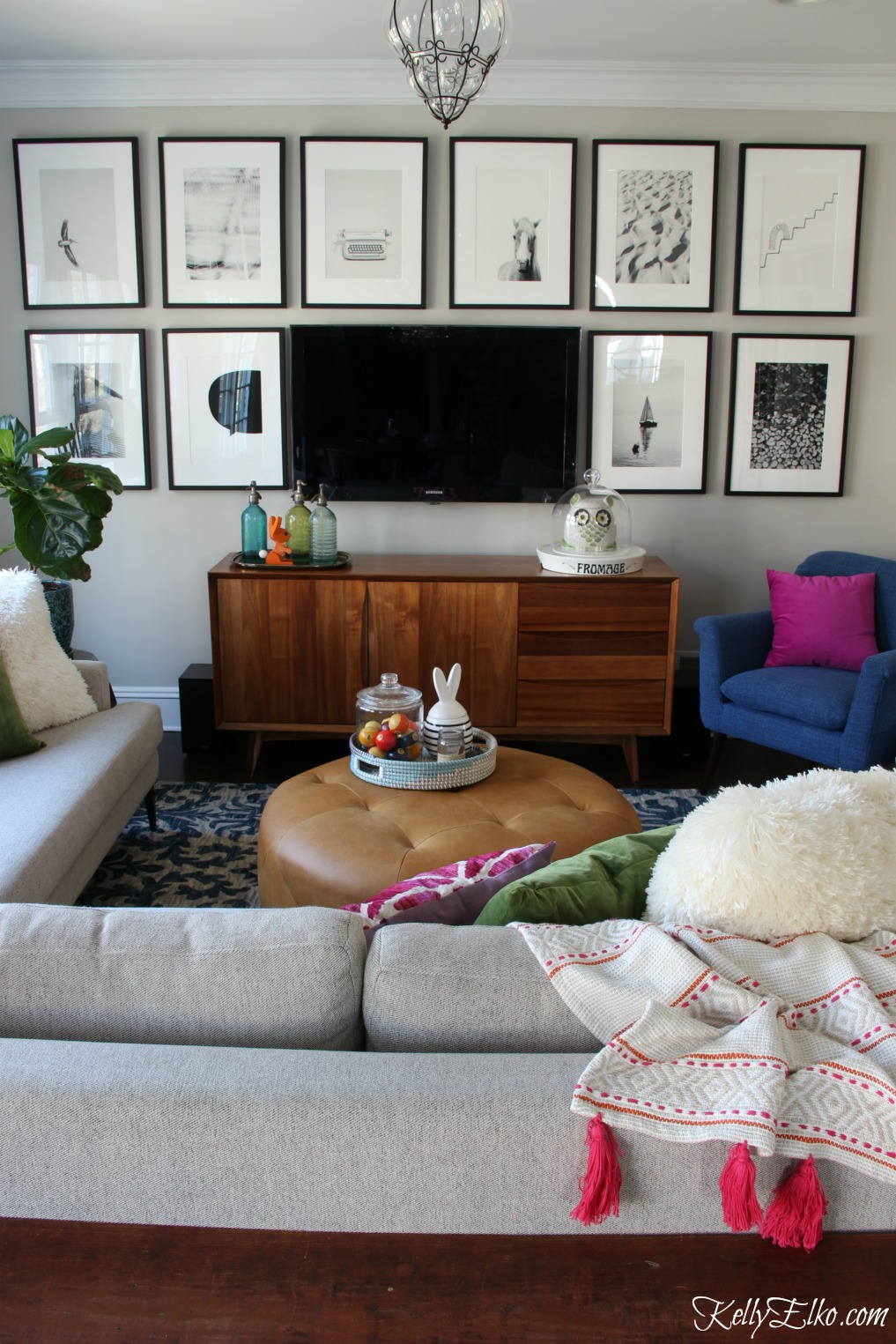 Love this cozy family room with TV gallery wall of black and white photos kellyelko.com #gallerywall #art #familyroom #homedecor