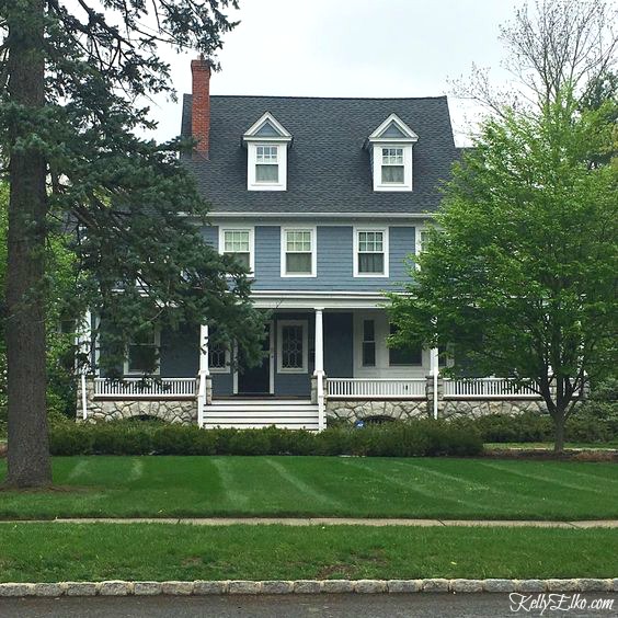 Blue House Exteriors - go bold with exterior paint like this beautiful blue with white trim and stone foundation kellyelko.com #bluehouses #bluepaint #curbappeal #bluehouse #paintcolors #exteriorpaint #blueexteriors