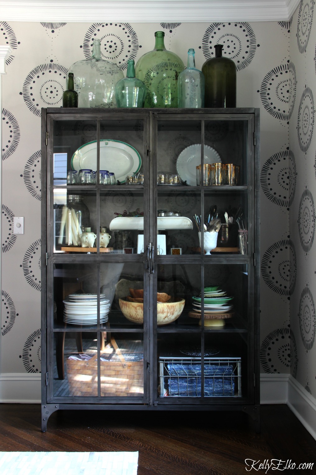 Forget wallpaper! This hand painted mural is like faux wallpaper minus the expense and I love the industrial metal cabinet and demijohn collection kellyelko.com #wallpaper #mural #diningroom #wallart #handpainted #collections #vintage