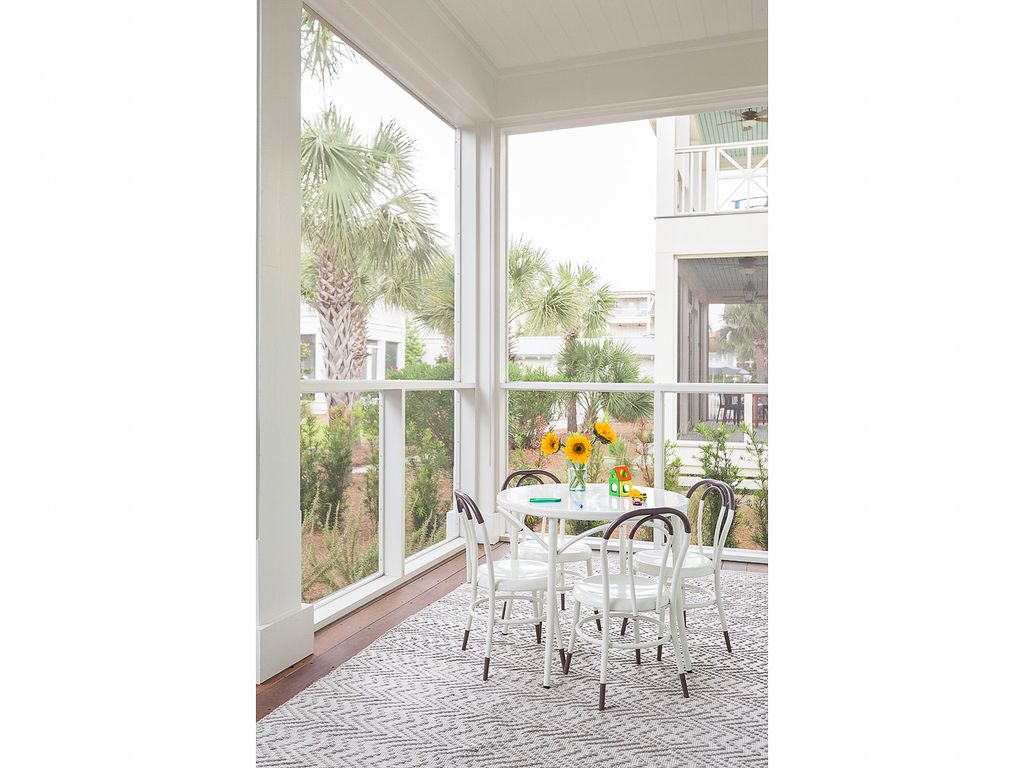 Beautiful screened in porch with bentwood chairs and a cozy rug kellyelko.com #porch #patio #interiors #decorate 