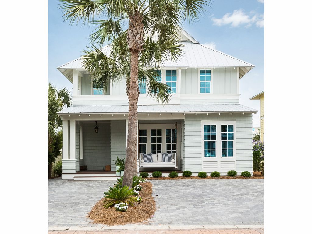 Eclectic Home Tour of the Sugar Palm House. Great curb appeal and love the hanging porch swing. kellyelko.com #hometour #decorate #coastalhome #florida 