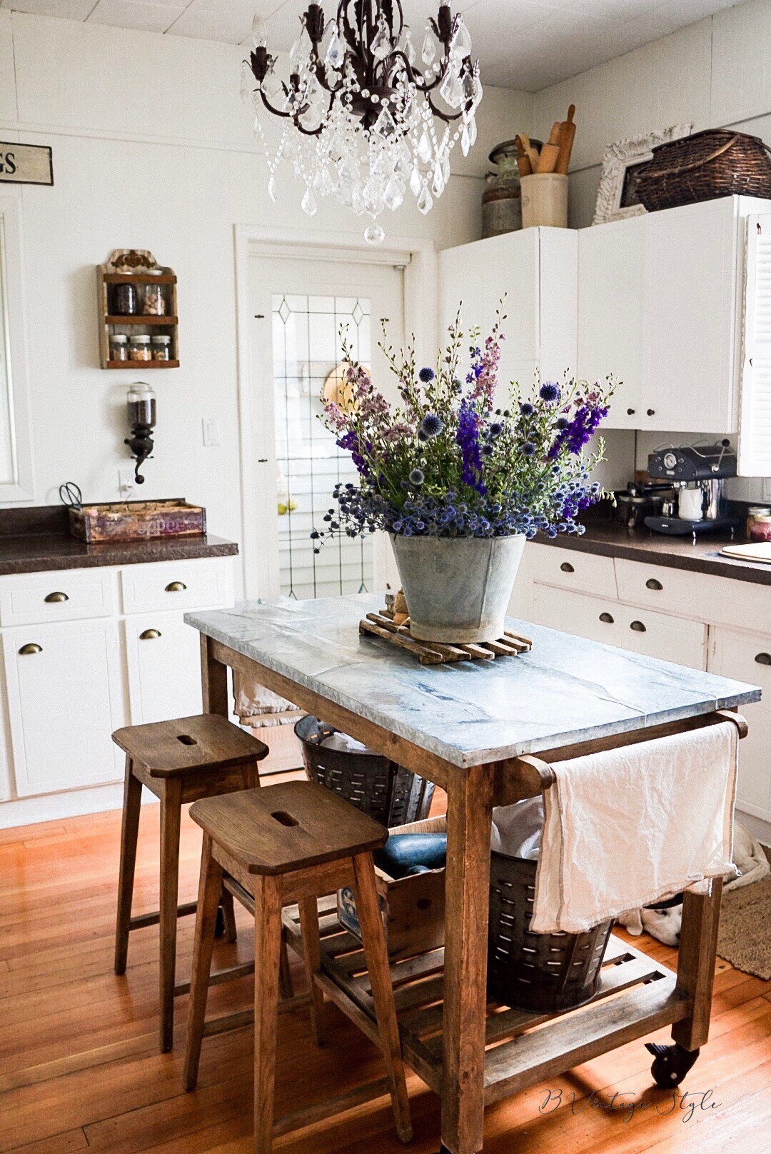 Love this farmhouse kitchen with white cabinets and wood and stainless steel island kellyelko.com #farmhousekitchen #farmhousedecor #farmhouse #kitchen #kitchenisland