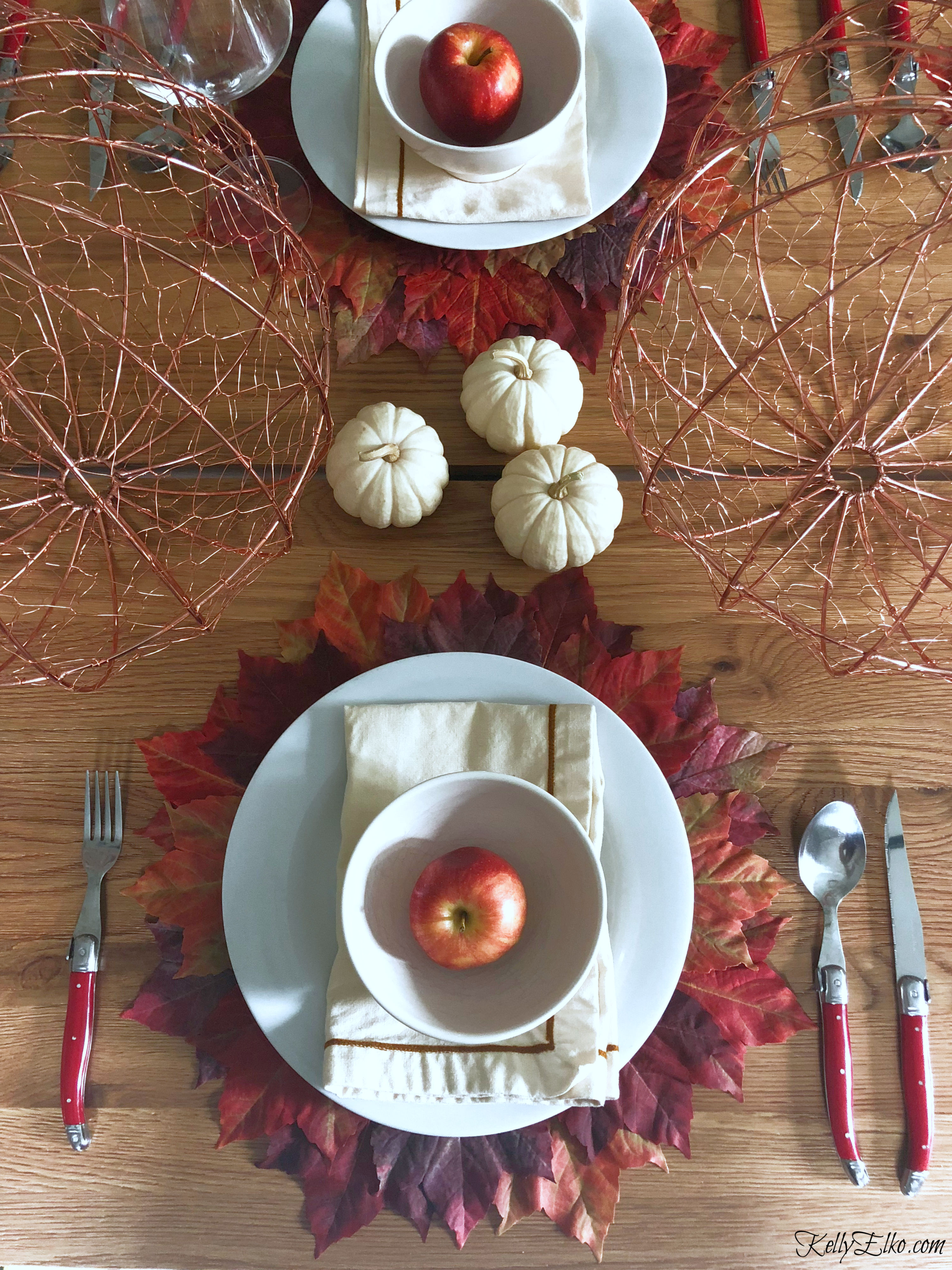 What a fabulous fall leaves tablescape - love these leaf placemats! kellyelko.com #fall #falltablescape #falldecor #fallleaves #thanksgiving #thanksgivingtable #tablescape #diningroom 