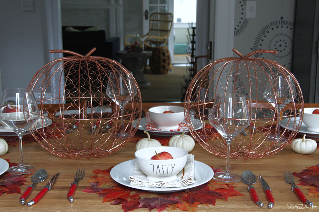 What a fabulous fall leaves tablescape with mixed metals, Rae Dunn bowls and copper pumpkins kellyelko.com #fall #falltablescape #falldecor #fallleaves #thanksgiving #thanksgivingtable #tablescape #diningroom 