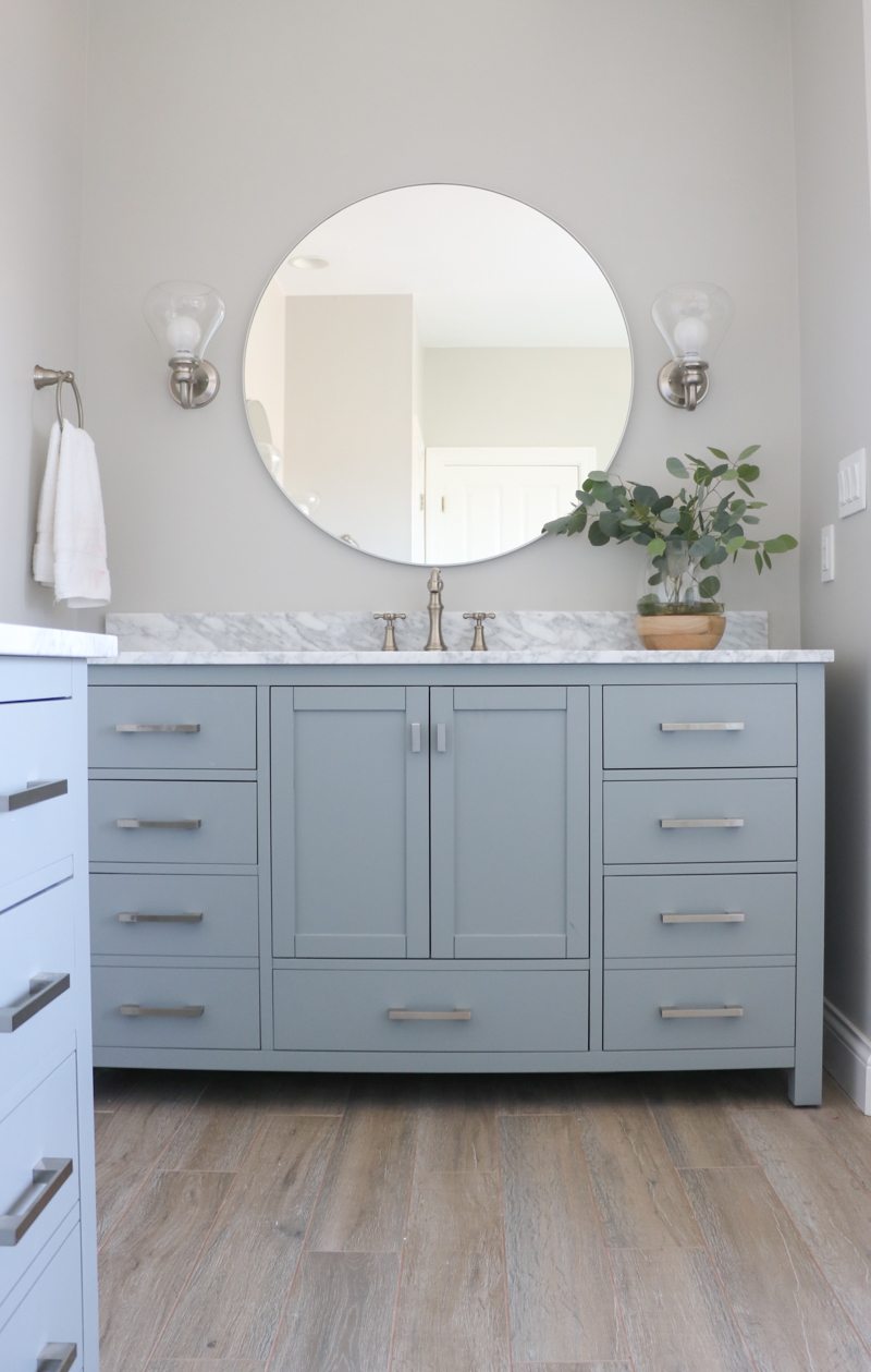 Beautiful blue bathroom vanity with large round mirror kellyelko.com #bathrooms #bathroomvanity #bathroomdecor 