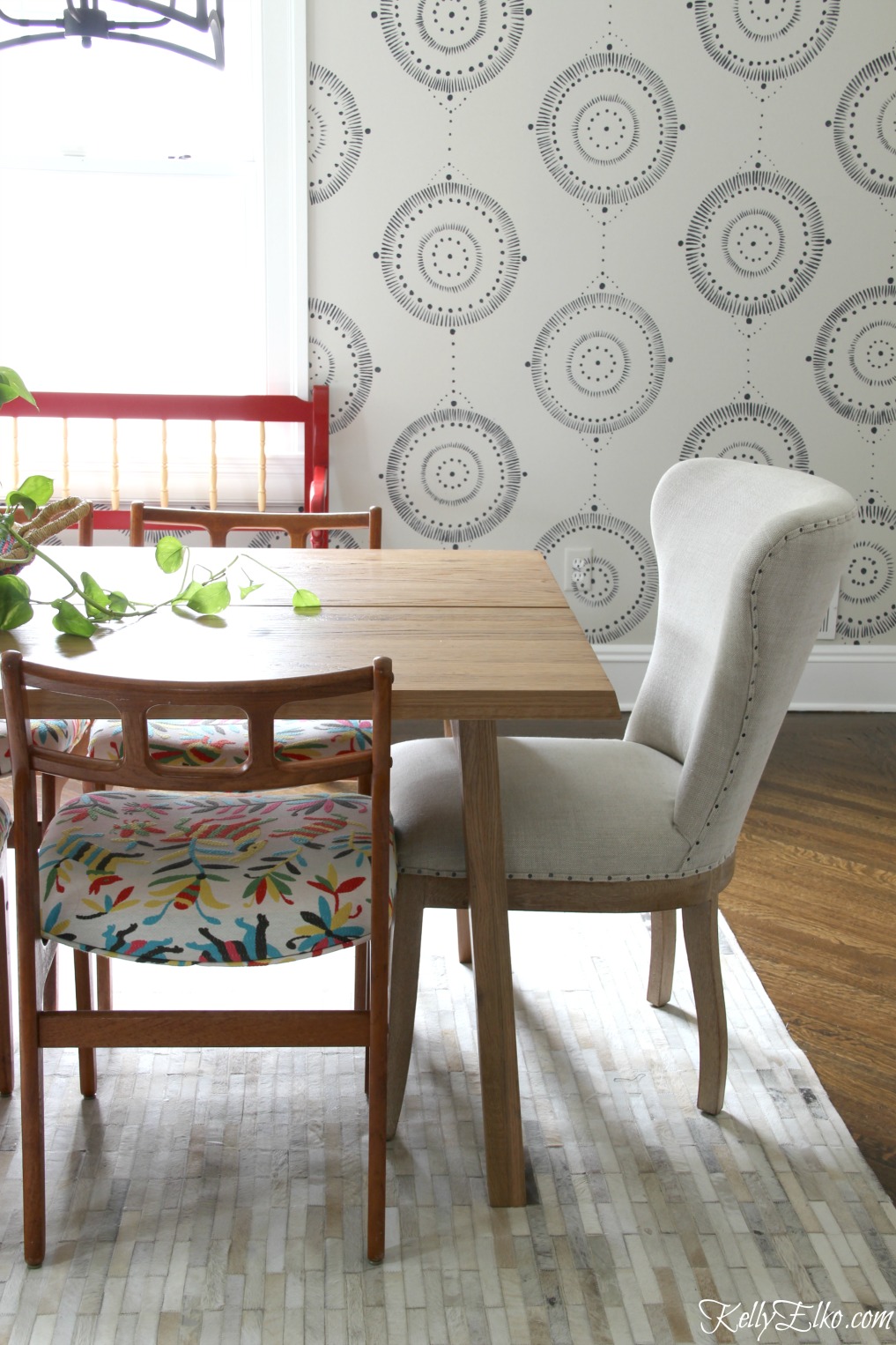 This eclectic dining room mixes Danish modern chairs with colorful otomi fabric and an Article dining table in solid oak kellyelko.com #diningroom #diningroomdecor #diningroomfurniture #midcenturymodern #midcentury #bohostyle #otomi #vintagestyle #interiordecor 