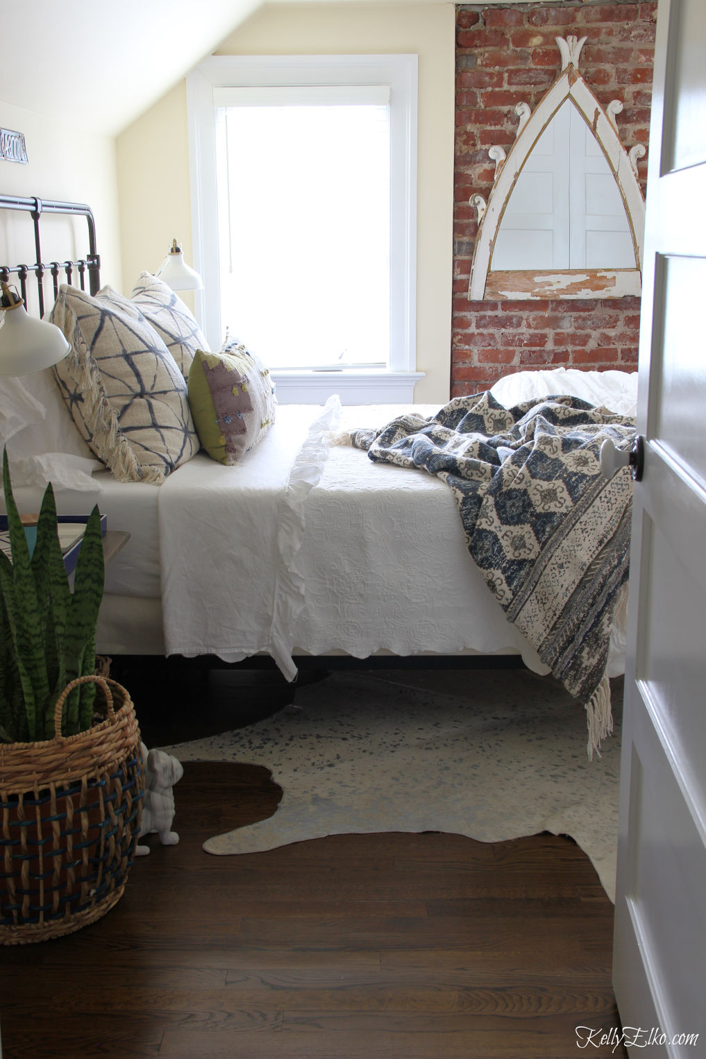 Guest bedroom decor - love the exposed brick wall and vintage style metal bed kellyelko.com #bedroom #bedrooms #bedroomdecor #interiordesign #vintagedecor #bohodecor 