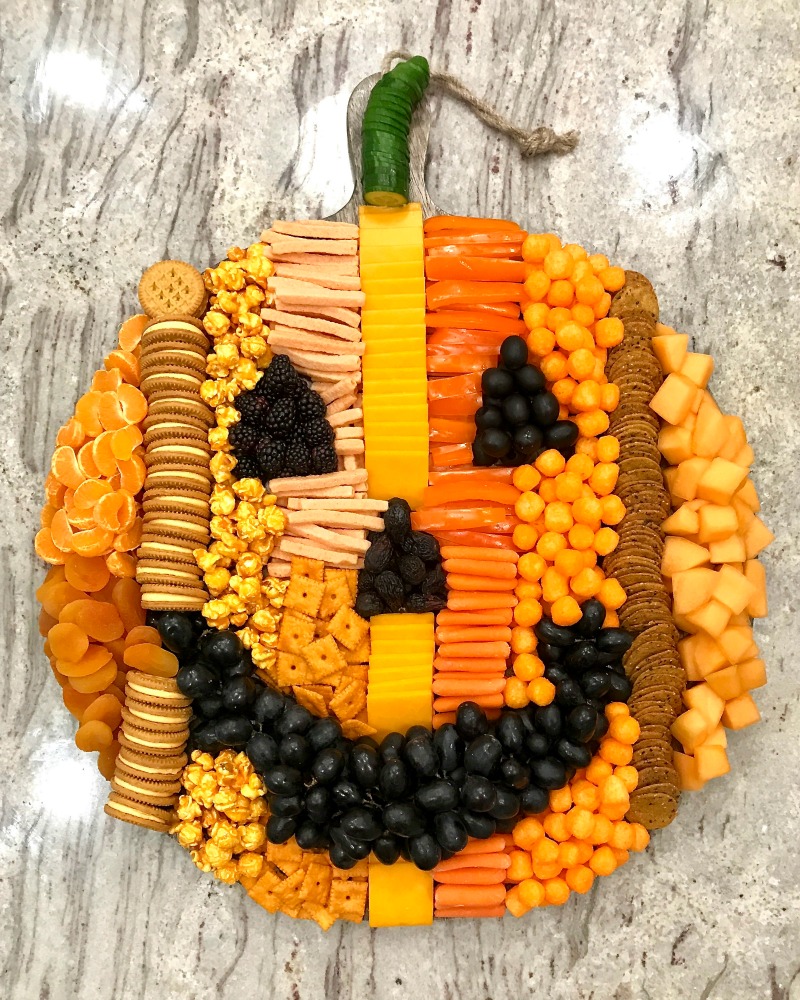 How fun is this pumpkin snack board! kellyelko.com #pumpkin #fallrecipes #fallfood #halloweenfood #halloweenparty #appetizers #fallsnacks