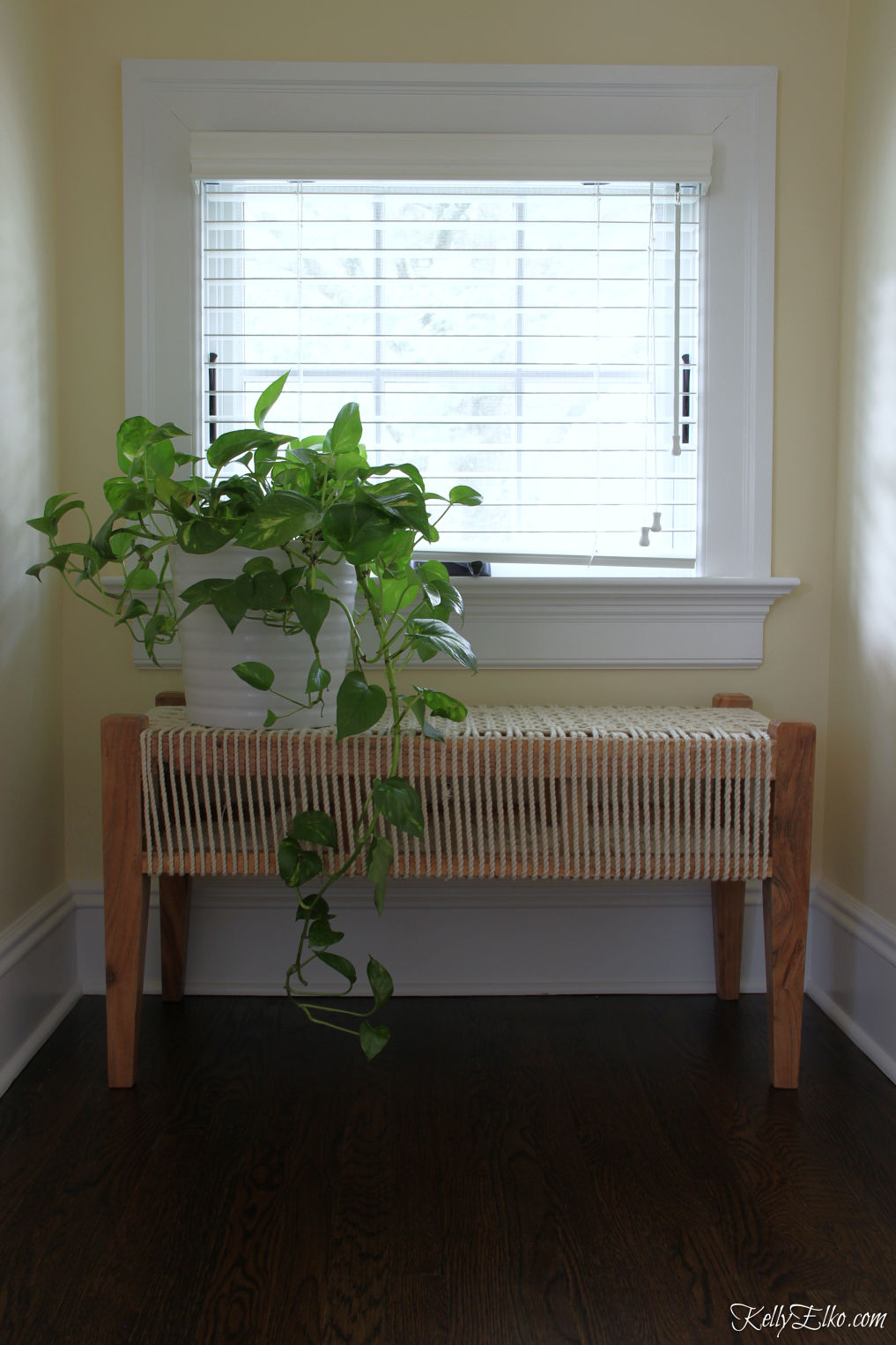 Love this woven rope bench tucked under a window - perfect plant stand kellyelko.com #bohodecor #benches #plants #houseplants 