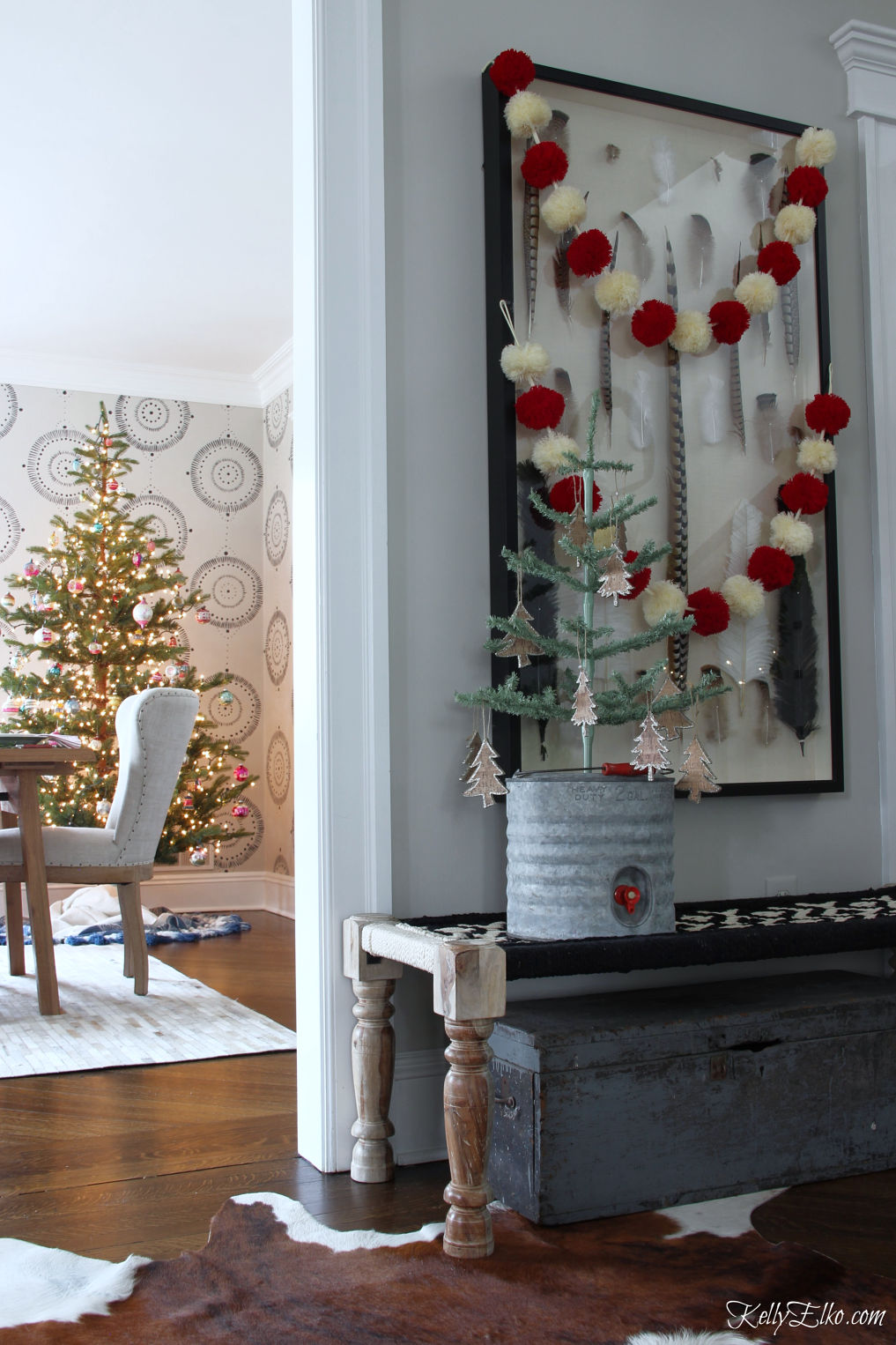 Beautiful Christmas home tour - love the pom pom garland hung over the art and the sparse Christmas tree kellyelko.com #christmas #christmasdecor #christmastree #christmasfoyer #christmasgarland #pompom #farmhousechristmas #vintagechristmas 