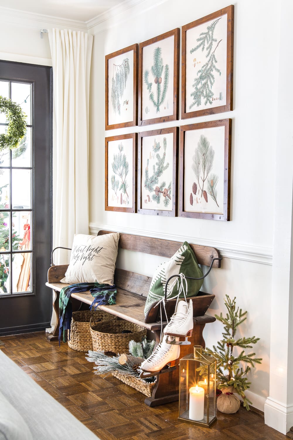 Beautiful Christmas entry with evergreen botanical gallery wall