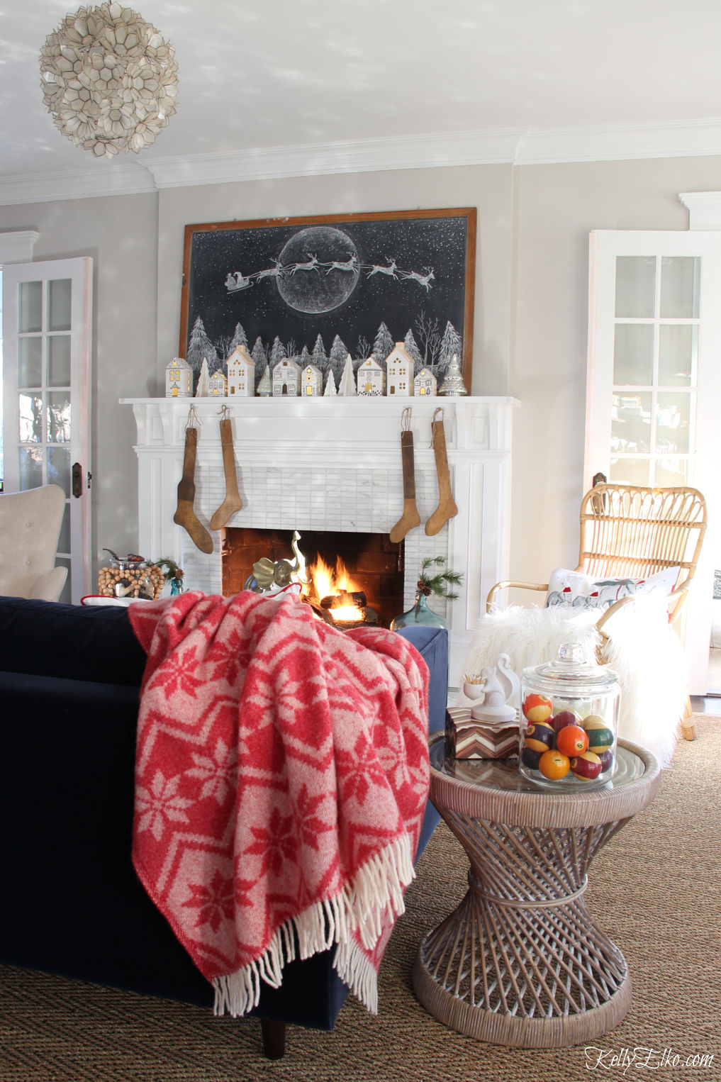 Beautiful Christmas home tour - love the giant Christmas chalkboard art and little houses on the mantel kellyelko.com #christmas #christmasdecor #christmasdecorating #christmasmantel #christmaslivingroom #farmhousechristmas #vintagechristmas #cozychristmas #livingroomdecor 