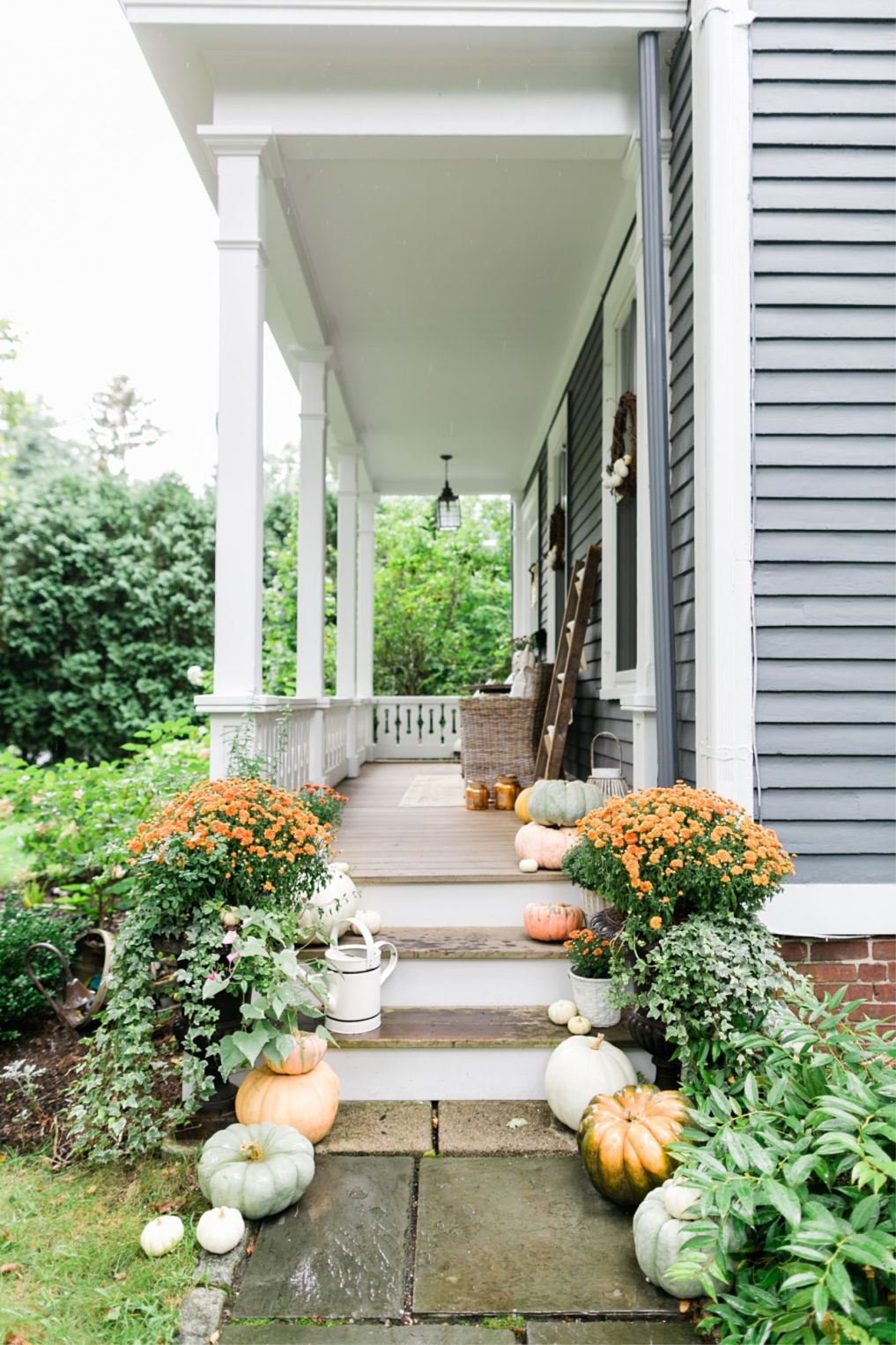 Love this charming old home with inviting porch and the detail of the porch railing kellyelko.com #fall #fallporch #falldecor #fallflowers #falldecorating 