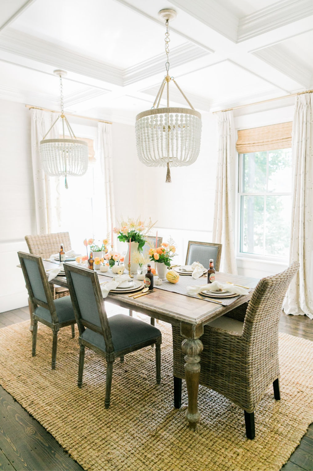 Beautiful dining room with a pair of beaded chandeliers hung from coffered ceiling kellyelko.com #farmhousestyle #farmhousedecor #cottagestyle #neutraldecor #diningroom #diningroomlighting #lighting #diningroomdecor #neutraldecor 