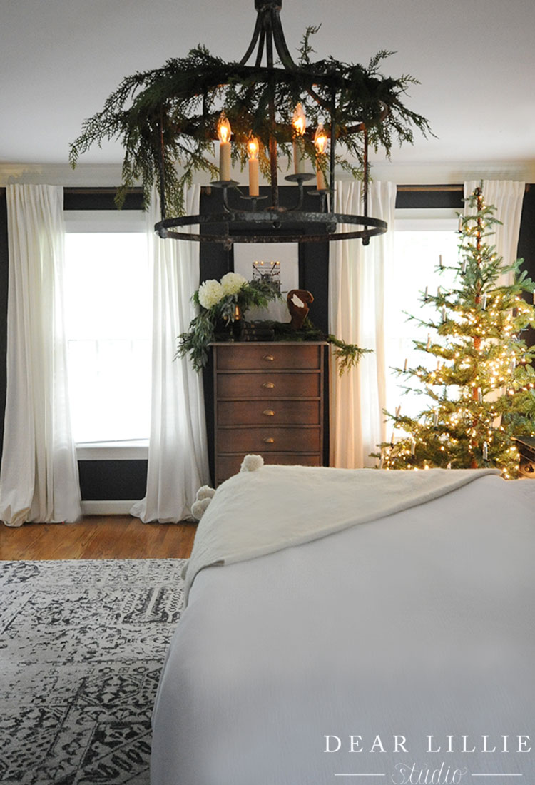 Love this Christmas bedroom with garland on the chandelier