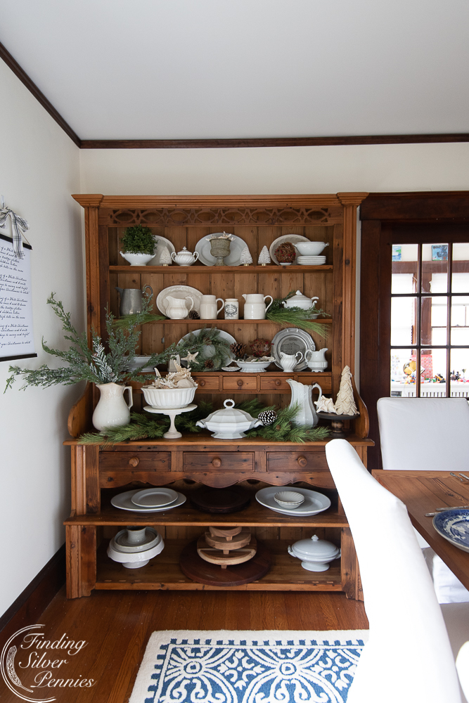 Love this beautiful pine hutch filled with white serving pieces and fresh greenery for Christmas 