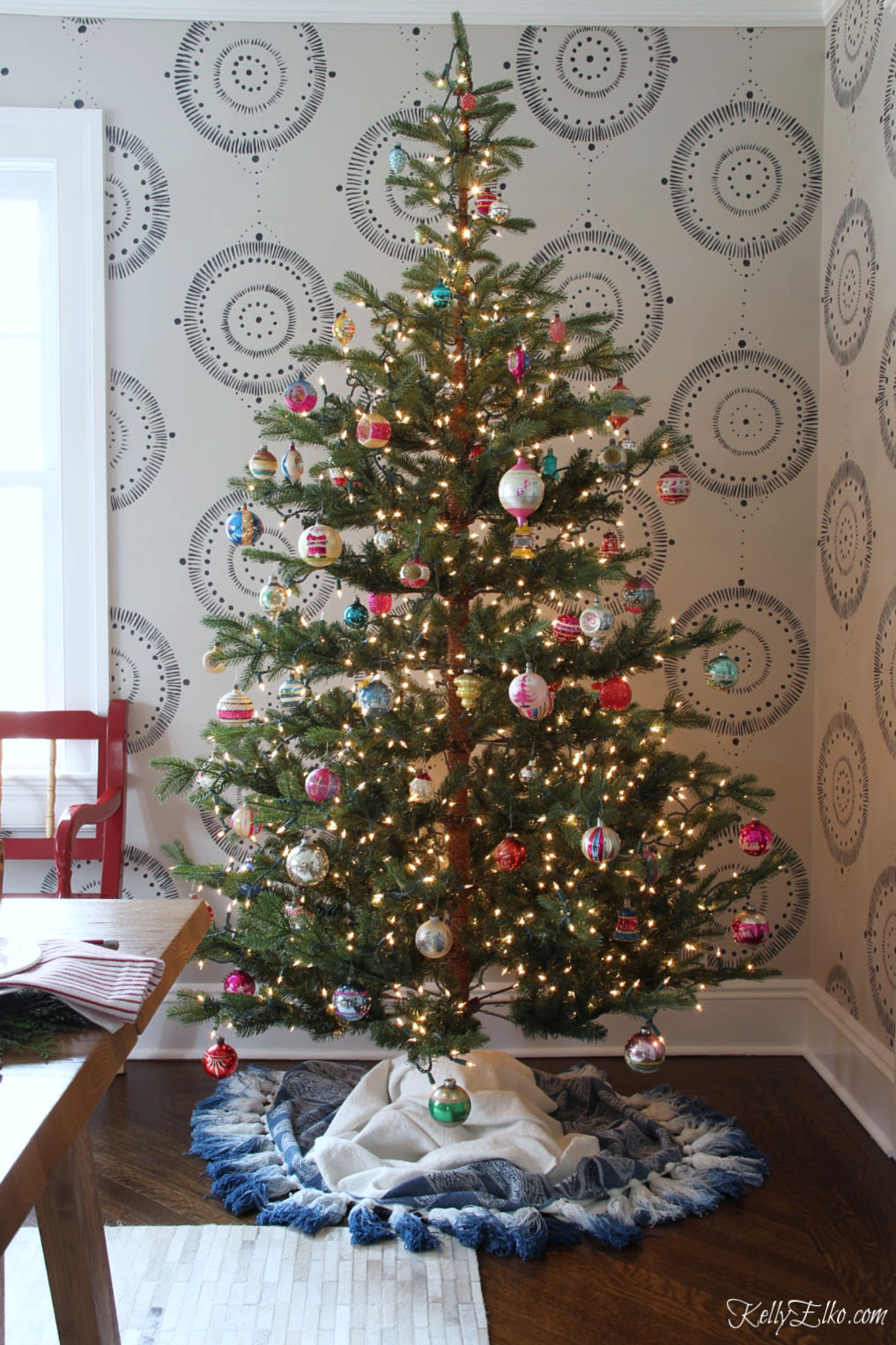 Love this sparse Christmas tree filled with vintage Shiny Brite ornaments and how cool is the tassel tree skirt kellyelko.com #christmastree #christmasdecor #christmasdecorations #christmaslights #diychristmas #treeskirt 