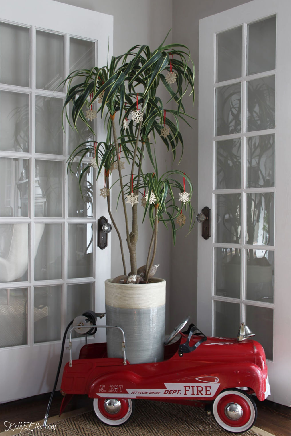 Love her Christmas home tour and palm tree Christmas tree tucked inside a vintage red fire truck pedal car kellyelko.com #christmas #christmastree #vintagechristmas #palmtree 