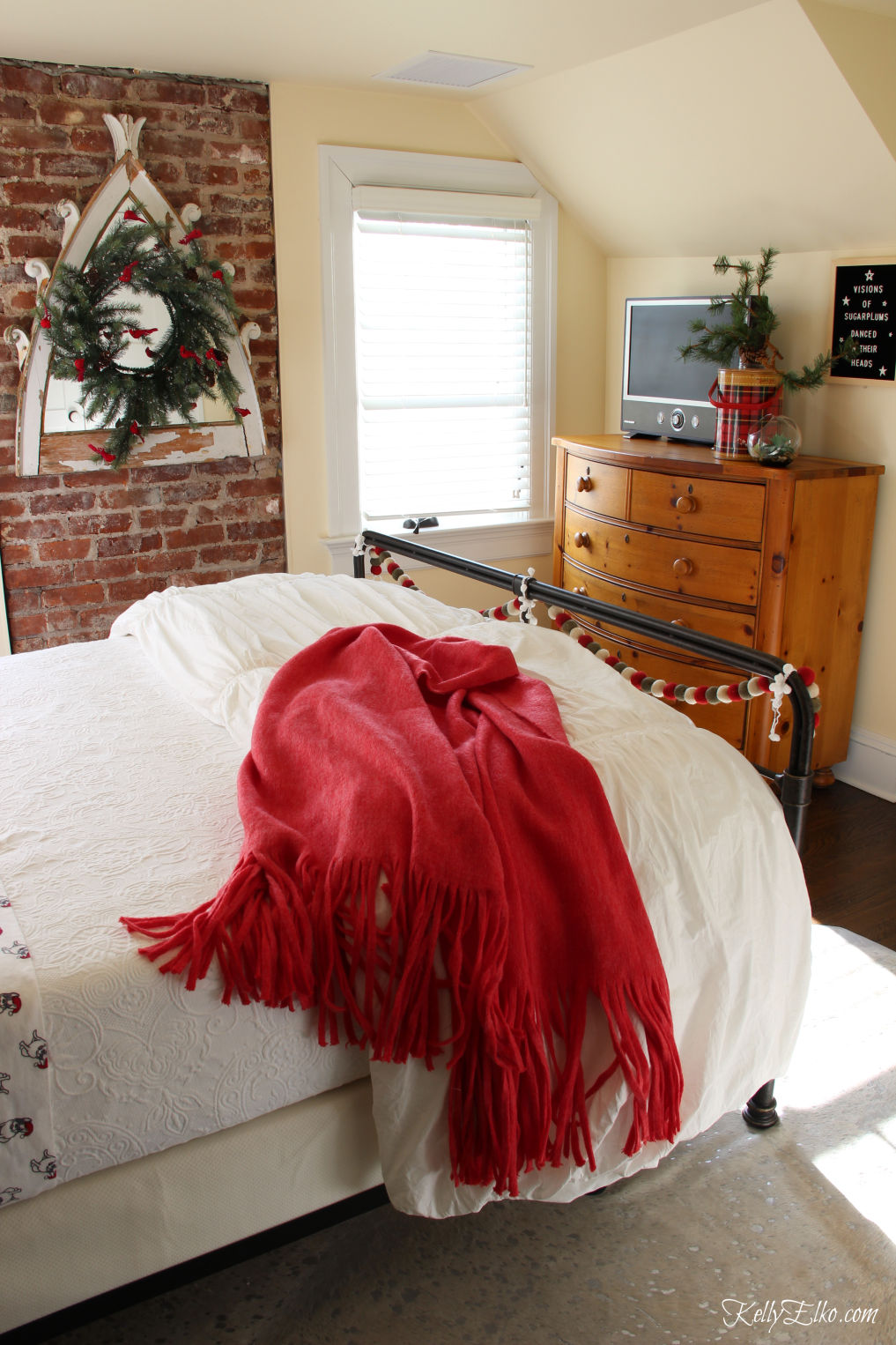 Cozy Christmas Guest Bedroom - love the flannel sheets, fringe throw and other whimsical decorating ideas kellyelko.com #christmas #christmasbedroom #christmasdecor #christmasdecorating #christmasbedding #christmaswreath #vintagechristmas 
