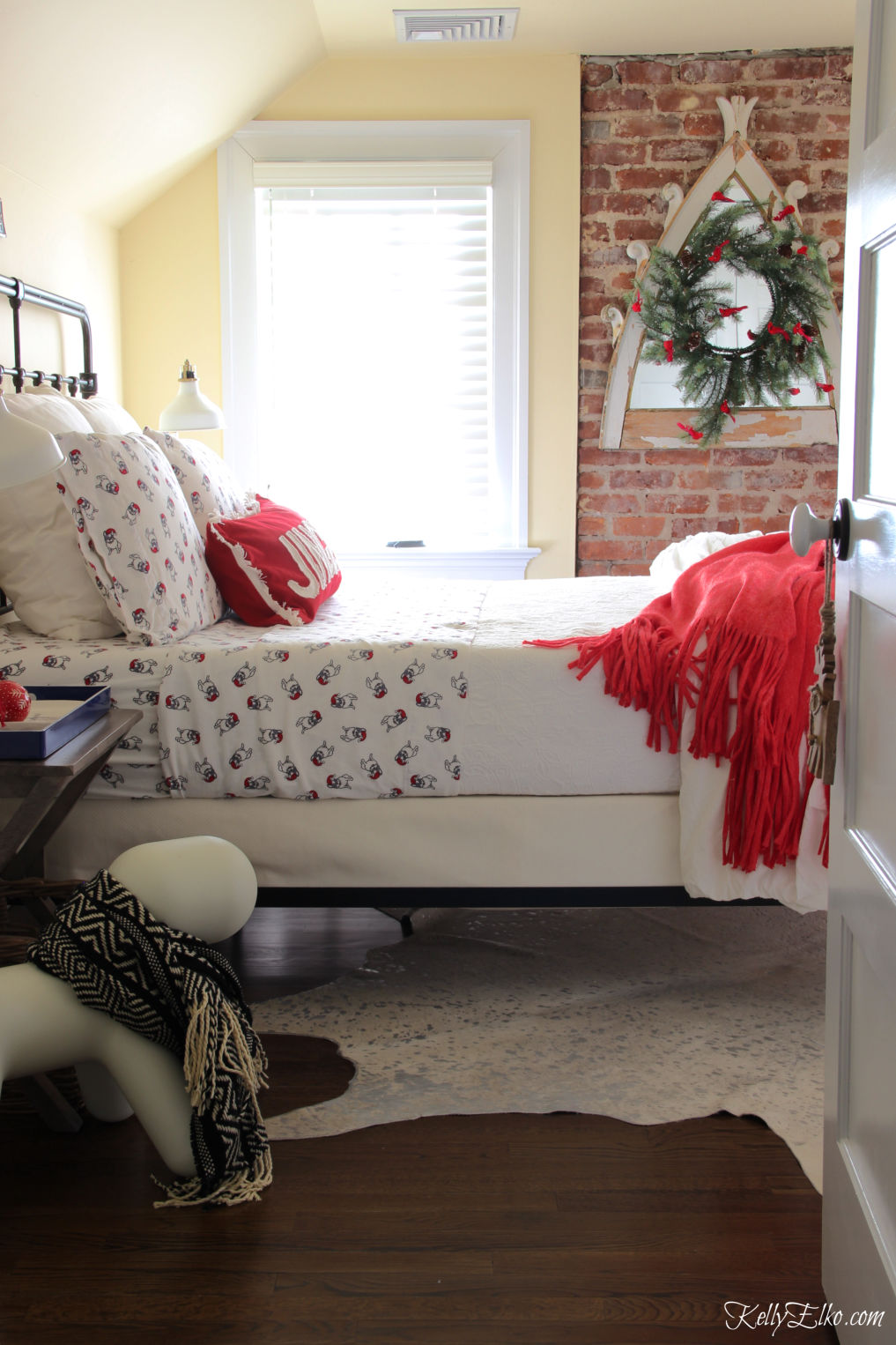 Cozy Christmas Guest Bedroom - love the flannel sheets, fringe throw and other whimsical decorating ideas kellyelko.com #christmas #christmasbedroom #christmasdecor #christmasdecorating #christmasbedding #christmaswreath #vintagechristmas 