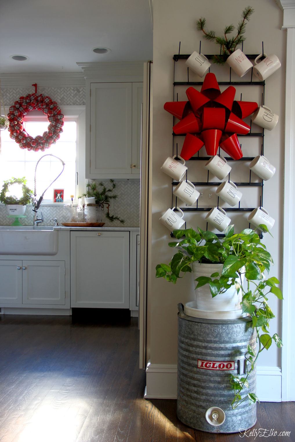 Love this Christmas kitchen with touches of red and green kellyelko.com #farmhousechristmas #christmaskitchen #christmasdecor #christmasdecorations #christmaswreath #raedunn 