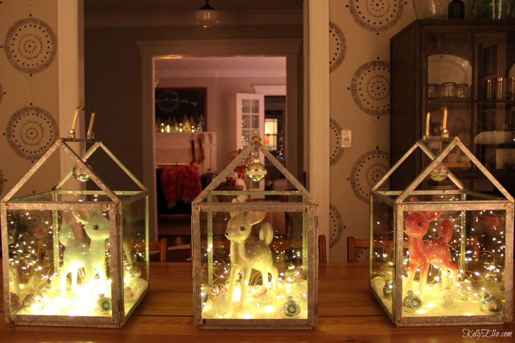 Love this winter centerpiece of three lanterns filled with fairy lights and cute little deer kellyelko.com #christmas #christmasdecor #christmascenterpiece #winterdecor #diychristmas #vintagechristmas #fairylights #kellyelko