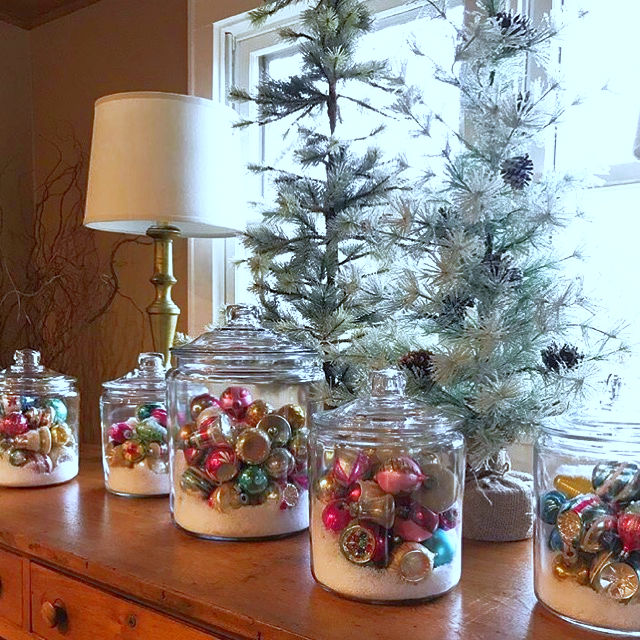 Shiny Brite Decorating Ideas - the most creative ideas for displaying Christmas ornaments like these clear glass jars filled with faux snow and ornaments kellyelko.com #vintagechristmas #christmasornaments #christmaswreath #christmasdecor #christmasdecorating #shinybrites #vintageornaments #ornaments #christmastree