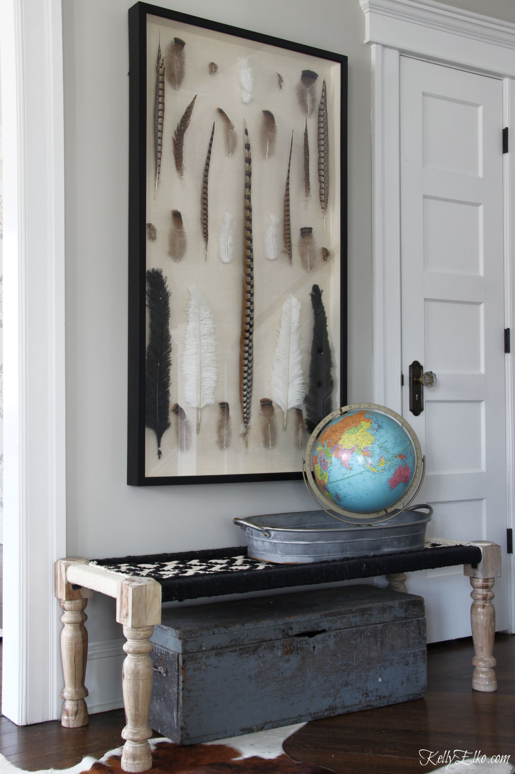 Love this huge feather shadow box in this black and white foyer kellyelko.com #foyer #foyerdecor #benches #art #shadowbox #vintagedecor #bohodecor #eclecticdecor 