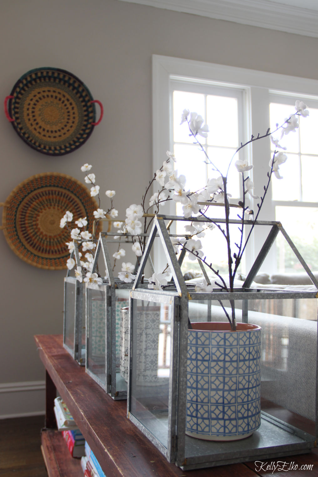 Love these lanterns filled with spring branches kellyelko.com #springdecor #spring #farmhousedecor #farmhousestyle #boho #bohostyle #familyroom #familyroomdecor 