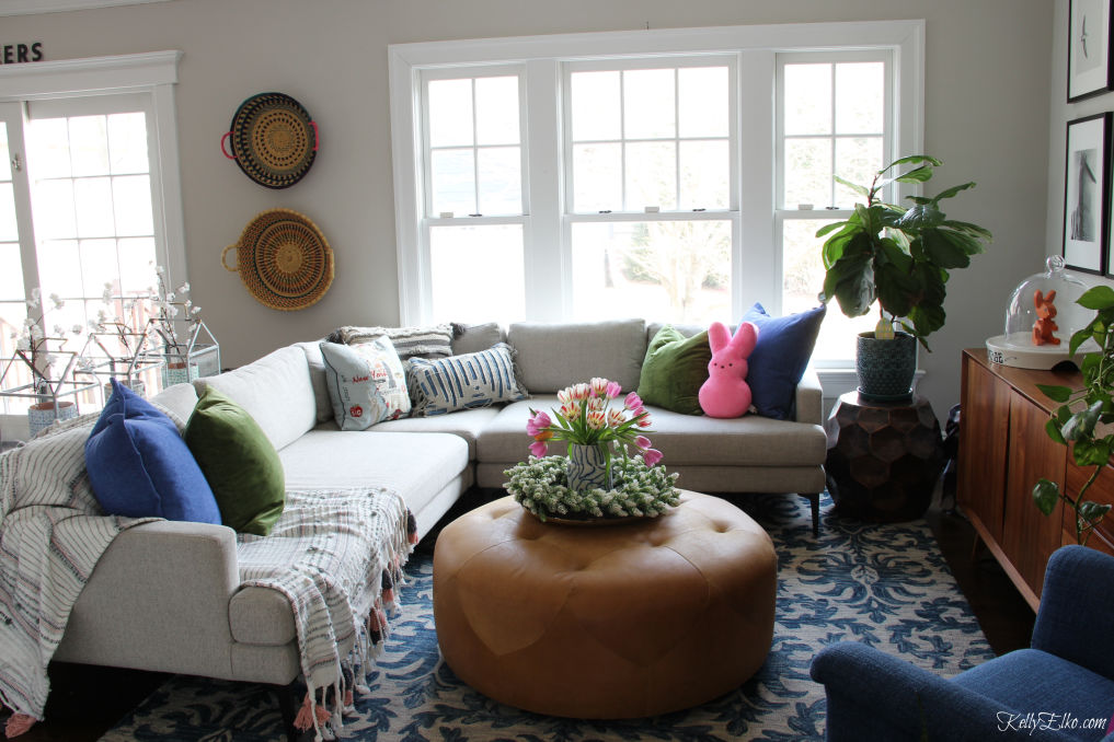 Love this cozy family room with sectional sofa, blue rug and huge leather ottoman kellyelko.com #sectionalsofa #familyroom #familyroomdecor #familyroomfurniture #ottoman #bohodecor #eclecticdecor #springdecor #peeps #fiddleleaffig 