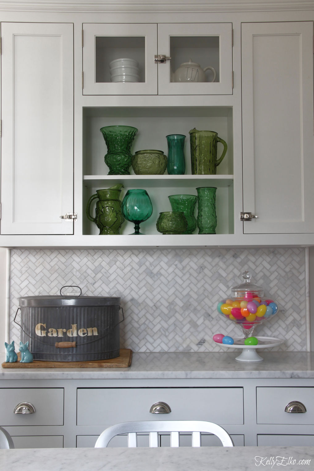 Love this white kitchen with open shelves displaying a vintage green glass collection kellyelko.com #kitchen #kitchendecor #openshelves #collection #vintagedecor #springdecor 